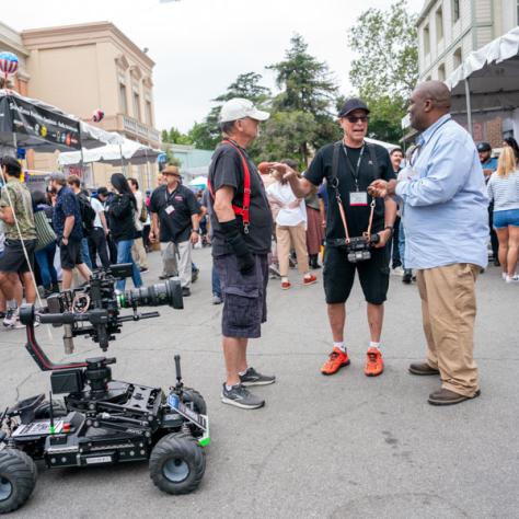 Candid shot of people working with cinema gear outside. 