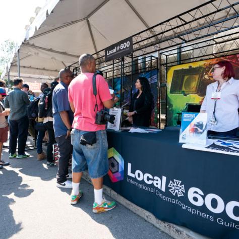 People standing at the Local 600 tent. 