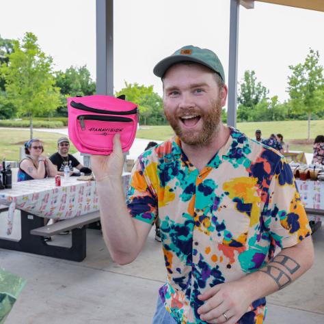 Man posing with pink fanny pack. 