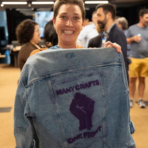 Photo of woman holding up jacket. 
