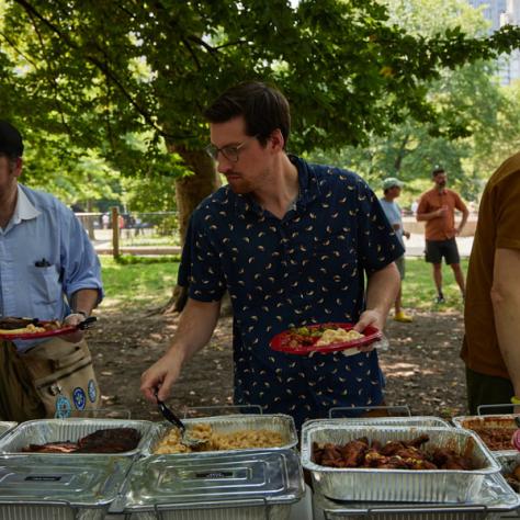 Man eating from picnic buffet. 