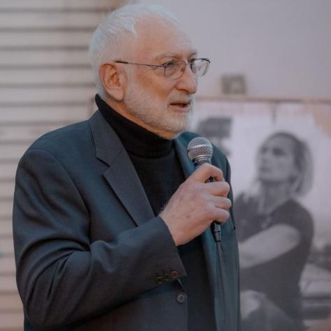 Man in a suit speaking into mic. 
