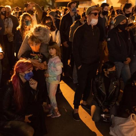 People standing at a vigil. 