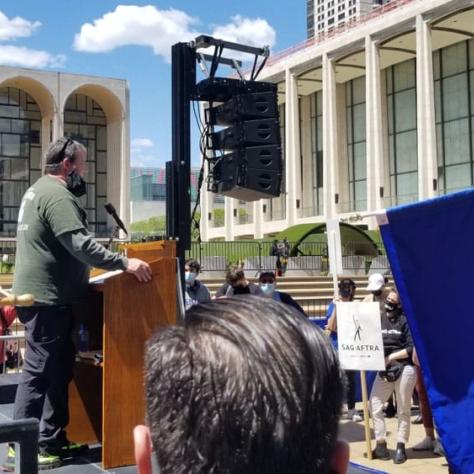 Person speaking on stage while people watch. 