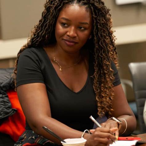 Woman watching and taking notes. 