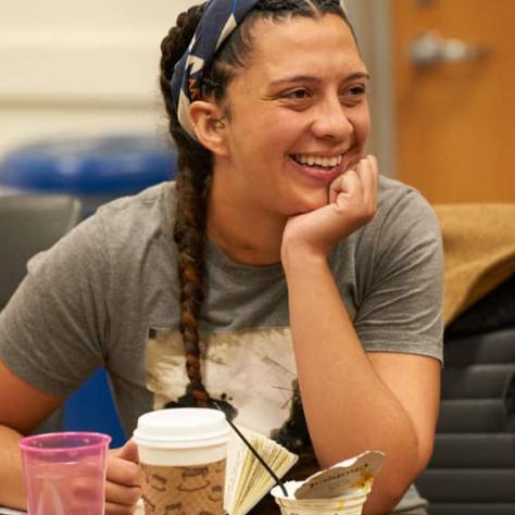 Woman sitting at table smiling. 