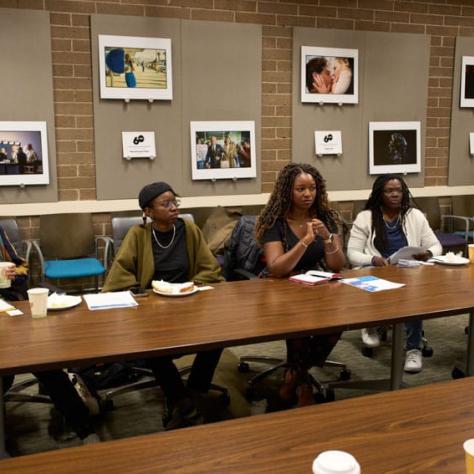 Women sitting on one side of a long table. 
