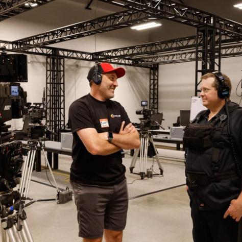 Two men talking with headphones on. 