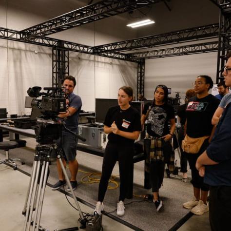 People watching a man behind a camera. 