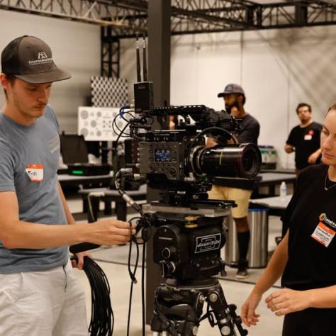 Two people working on a camera. 