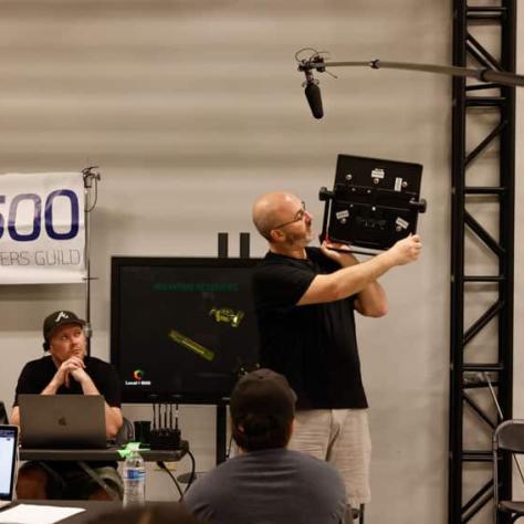 Man holding something up in front of people. 