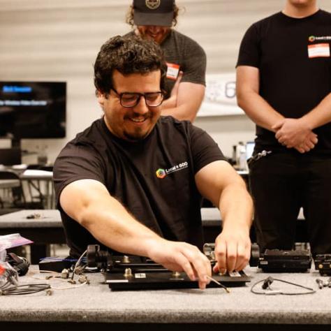 Man at table working with gear. 