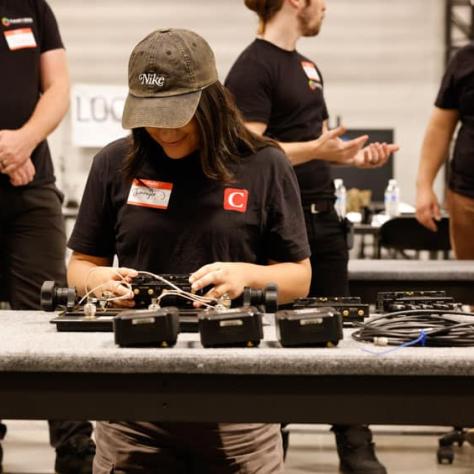 Woman working with gear at a table. 