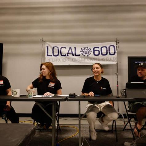 People sitting at a table under a "Local 600" banner. 