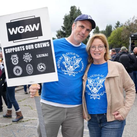 People posing for photo with signs. 