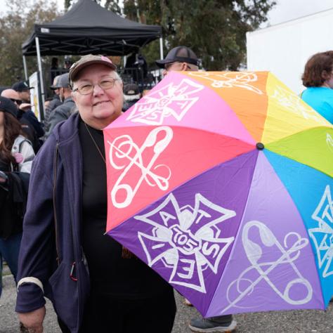 Person posing for photo with colorful umbrella.