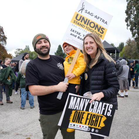 People posing for photo with signs.