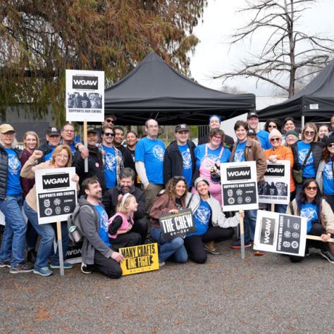 People posing for photo with signs.