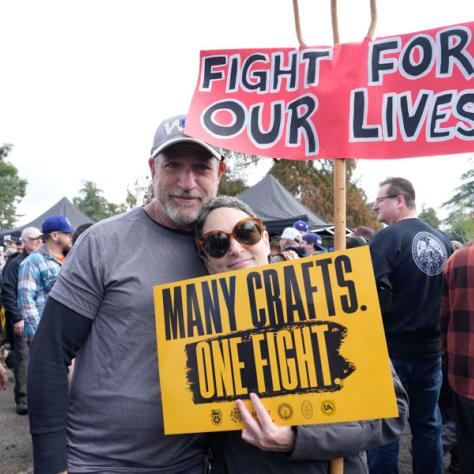 People posing for photo with signs.