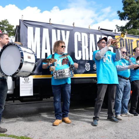 Band playing in front of truck with sign. 