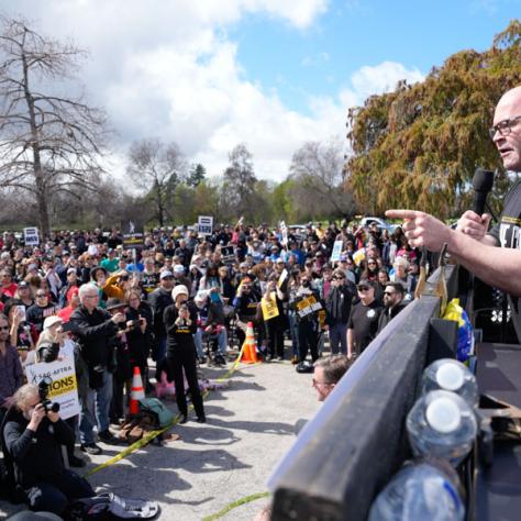 Man speaking to crowd at rally. 