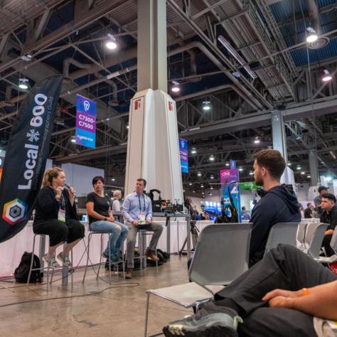 People speaking on panel at NAB show. 