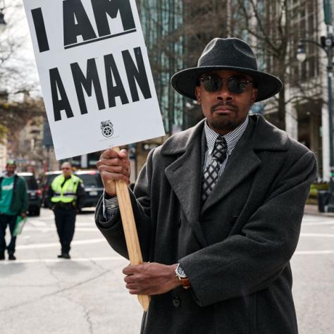 Man holding 'I am a man' sign. 