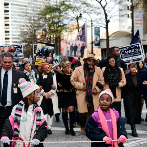 People marching with signs at event. 