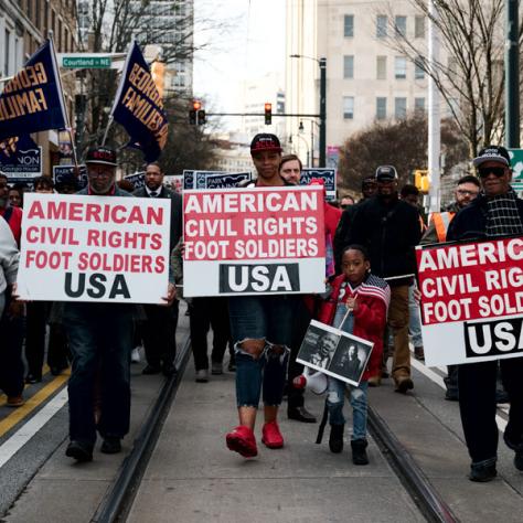 People marching with signs at event.