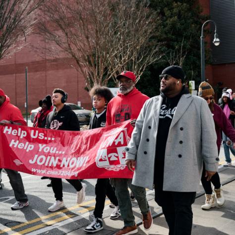 People marching with signs at event.