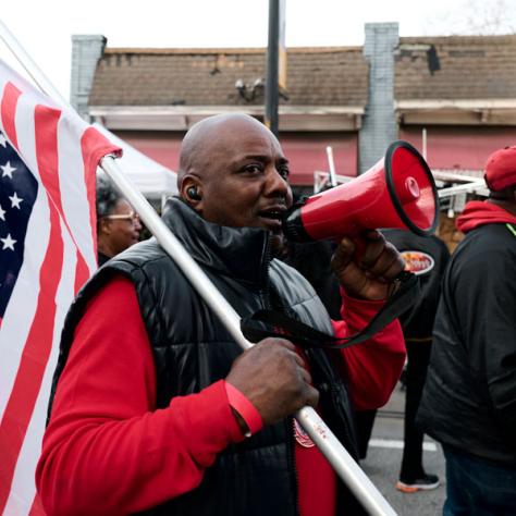 Man marching with American flag and megaphone. 