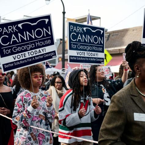 People marching with signs at event.