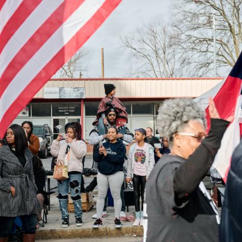 People marching with flags at event.
