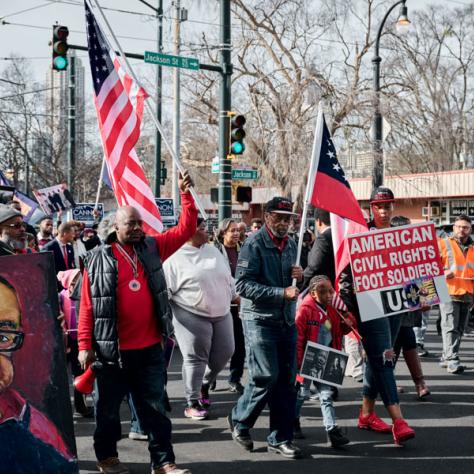 People marching with signs and flags at event.