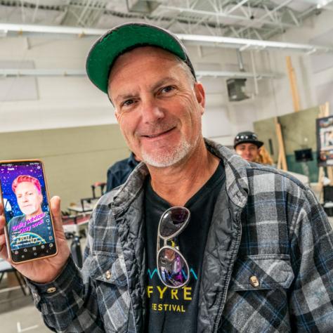 Man posing with photo on phone. 
