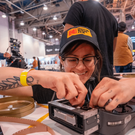 Woman kneeling at table smiling and working on equipment. 