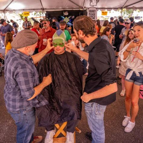 People looking at someone getting costume done. 