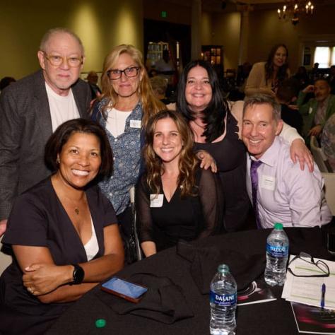 People posing for photo at table. 