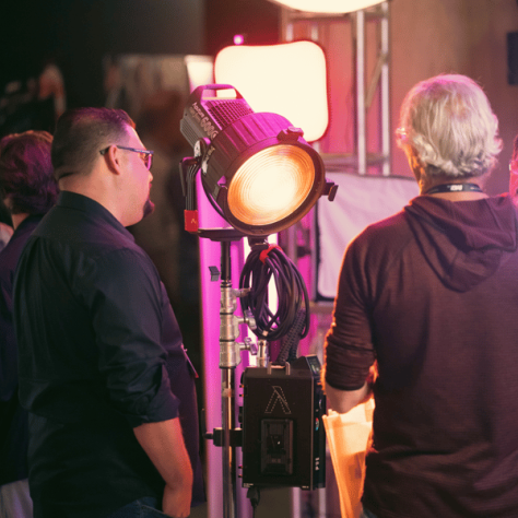 Men standing around a big light. 