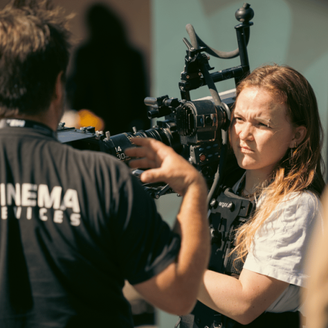 Girl working behind a camera. 