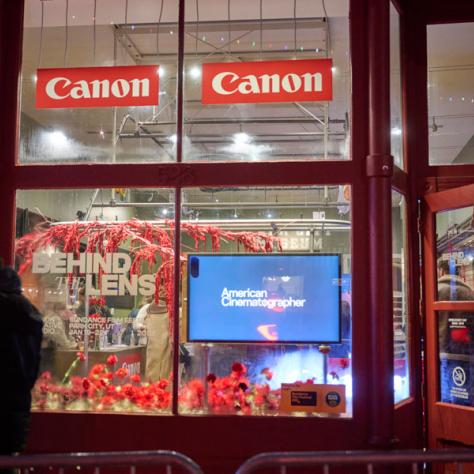 View of store window with 'Canon' ads. 