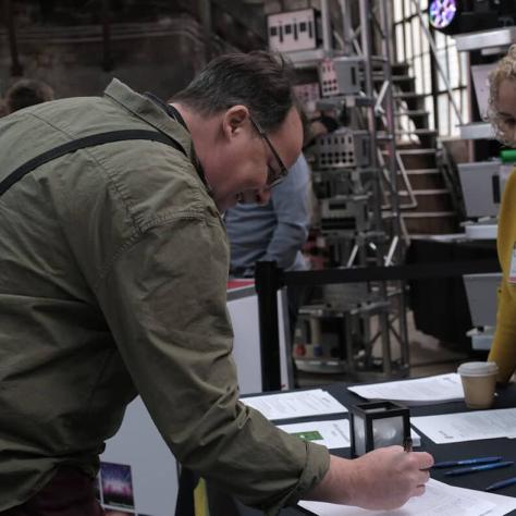 Man signing something on table. 