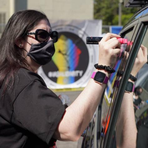 Person drawing on a car window. 