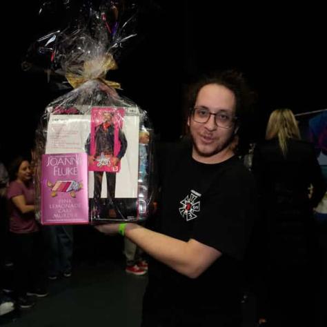 Man posing for photo and holding up prize. 