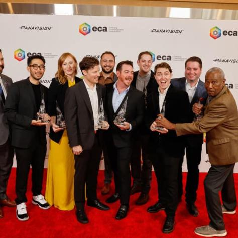 Group of award winners posing for photo with awards. 