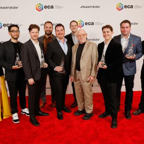 Group of award winners posing for photo with awards. 