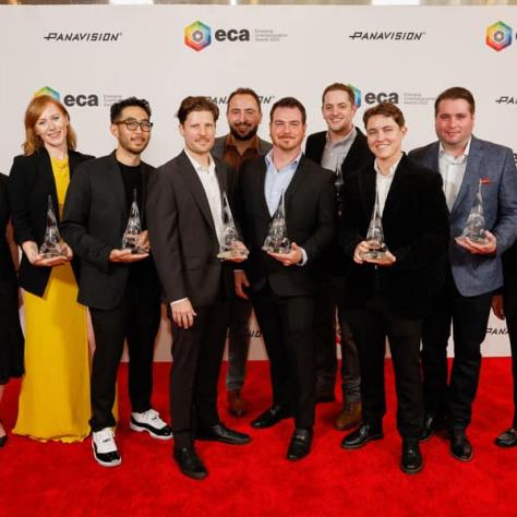 Group of award winners posing for photo with awards. 