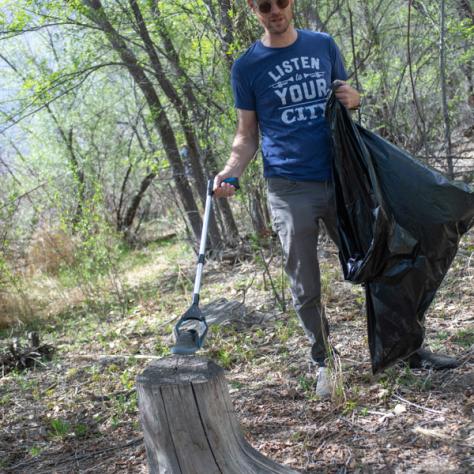Person picking up trash outside. 