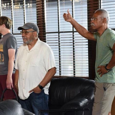 Candid photo of two men looking at something. 
