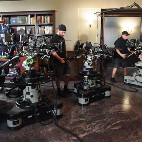 Three people working behind cameras. 